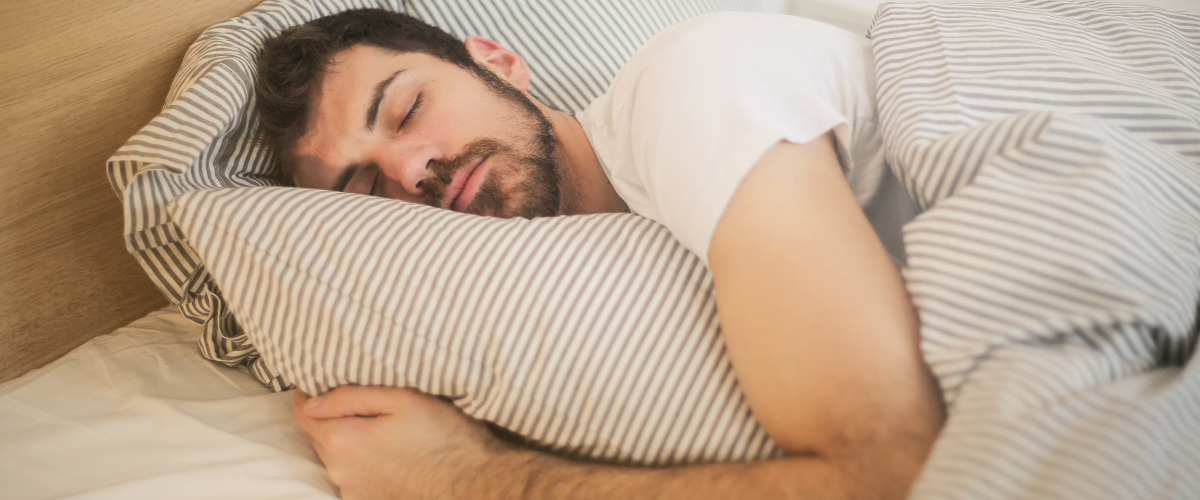 Man slaapt in zijn bed