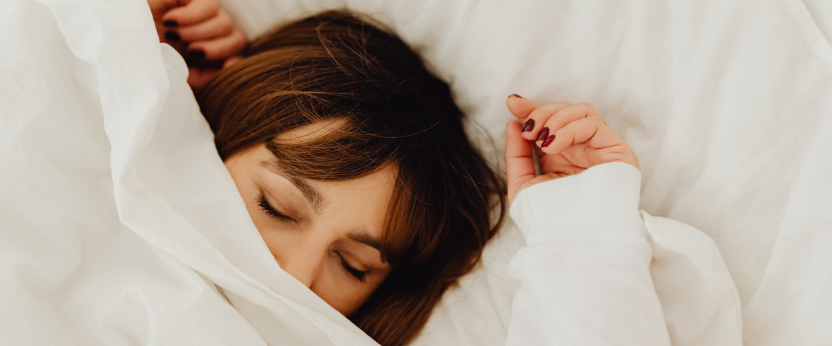 Vrouw ligt heerlijk te slapen in bed