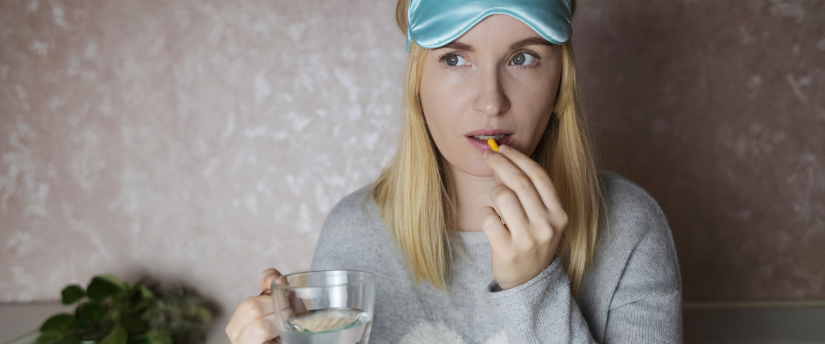 Vrouw neemt een melatonine pil voor het slapen gaan