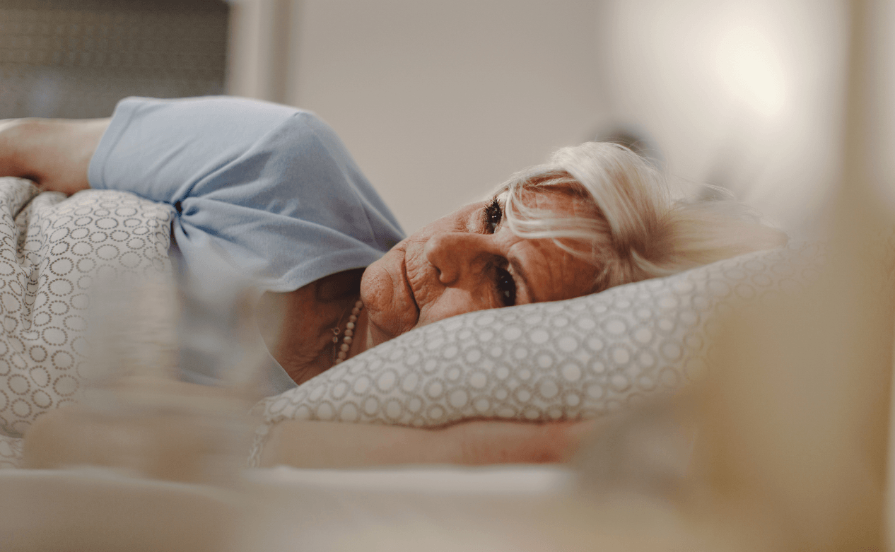 Vrouw ligt oncomfortabel in bed