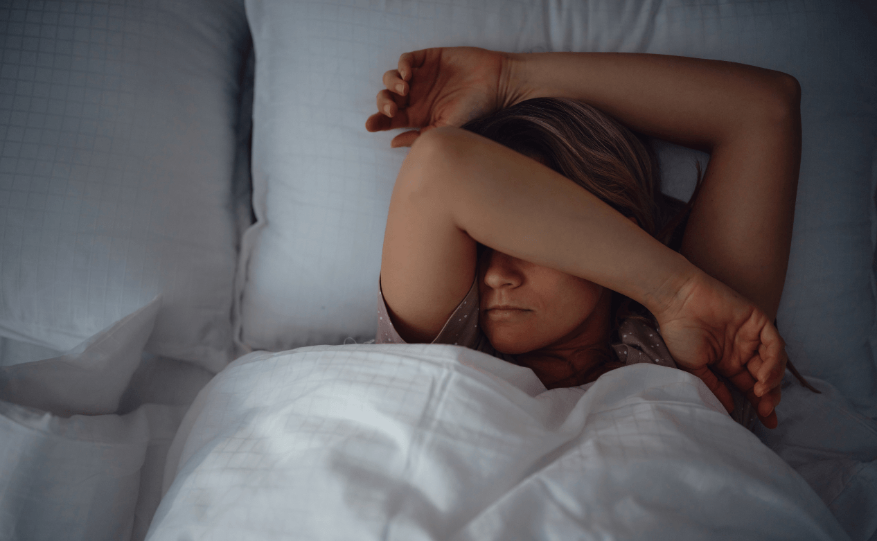 Vrouw ligt oncomfortabel in bed