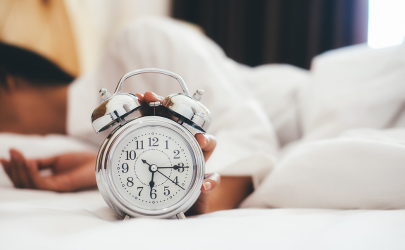 Vrouw ligt in bed te snoozen