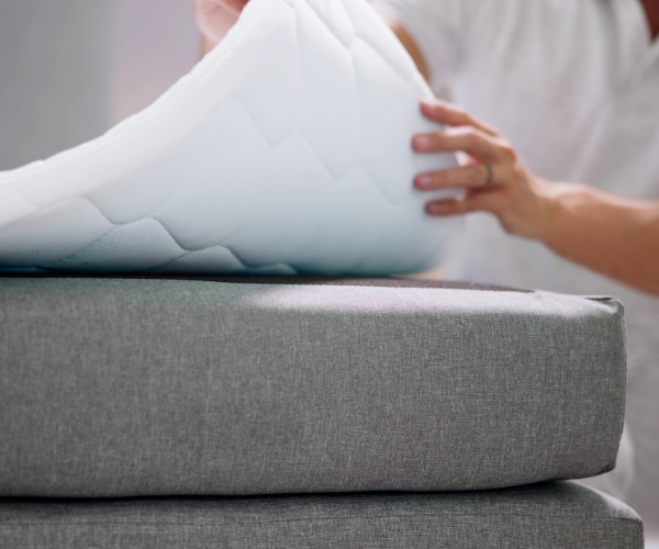 Man tilt de hoek van het topmatras op van het bed